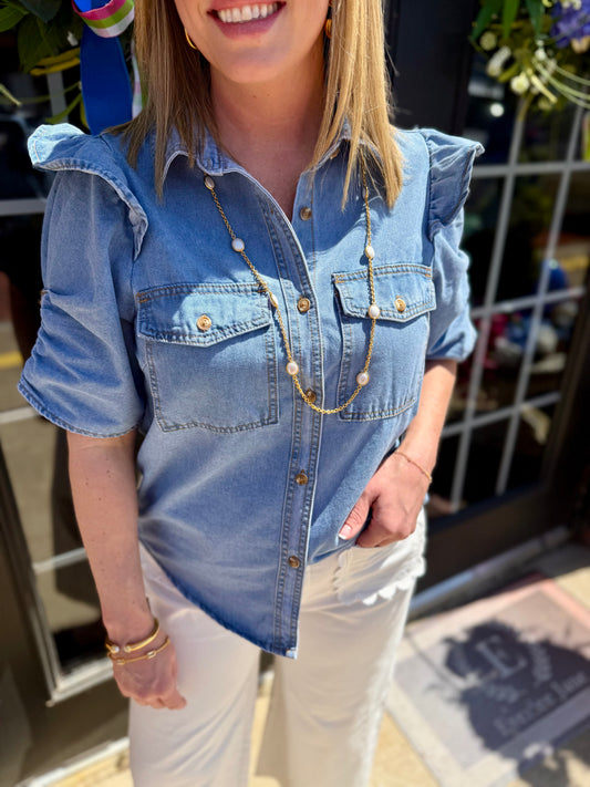 Ruffle Detail Button-Up Denim Shirt with ruffled shoulders. Available in sizes XS-XL.