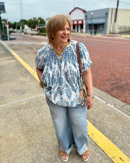 Short Sleeve Smocking Top available in sizes XS-XL. Features smocked detail, short sleeves, and relaxed fit.