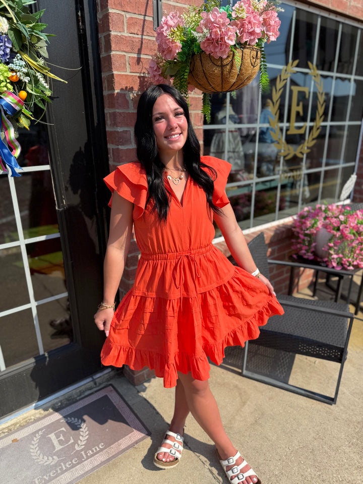Bright orange Jacket Pride Flutter Sleeve Dress; available in sizes XS–XL.