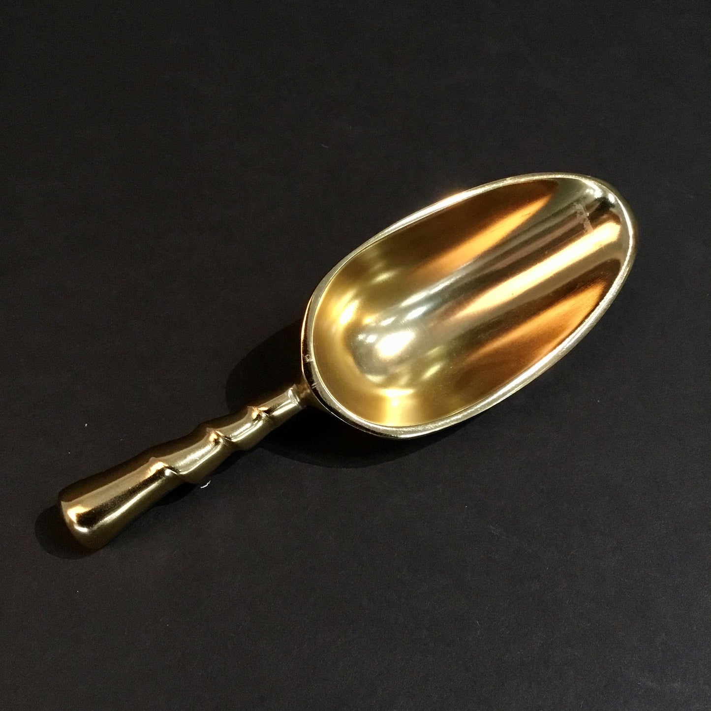 The Aluminum Gold Plated Small Ice Scoop features an exquisite design with an ornate handle, perfect for enhancing beverage service. Sizes available: Small.