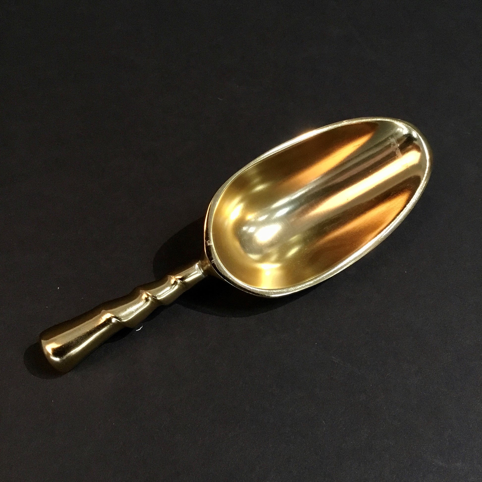 The Aluminum Gold Plated Small Ice Scoop features an exquisite design with an ornate handle, perfect for enhancing beverage service. Sizes available: Small.