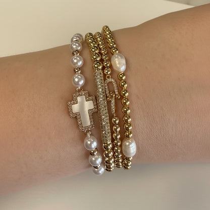 Set of four gold and pearl stretch beaded bracelets with cross charm and bar accent. Available in S, M, L sizes.