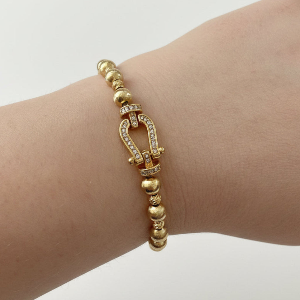 Beaded Gold Dipped Stretch Bracelet with horseshoe-shaped diamond-studded clasp; available in small, medium, and large sizes.