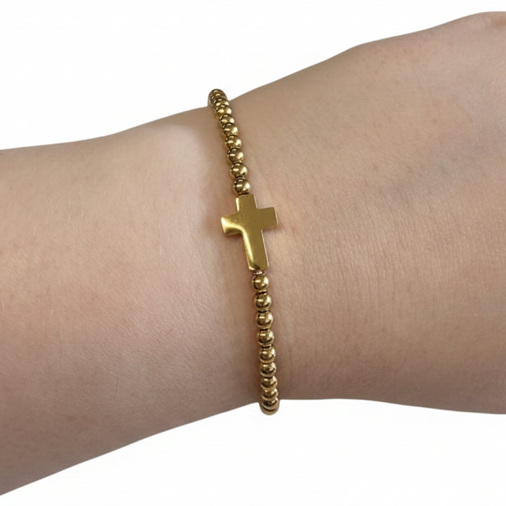 Beaded Gold Dipped Stretch Bracelet with central gold cross charm; available in S, M, and L sizes.
