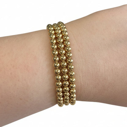 Beaded Gold Dipped Stretch Bracelets with shiny gold round beads. Available in S, M, L sizes.