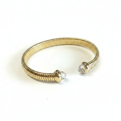 Stainless steel gold dipped cuff bracelet with ribbed texture, clear cubic zirconia ends. Sizes: S, M, L.