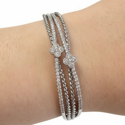 Three intertwined silver bands with CZ stones and floral accents. Available sizes: S, M, L.