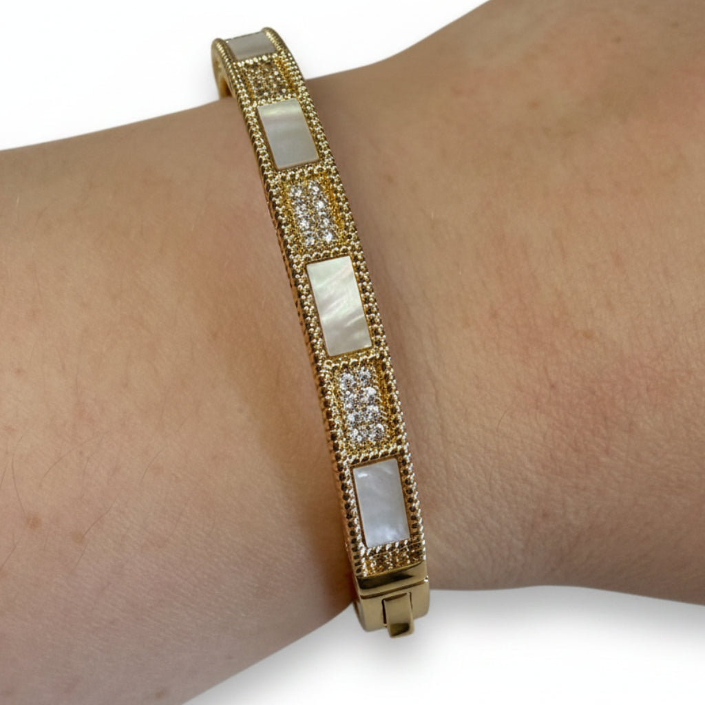 Gold hinged CZ bracelet with mother-of-pearl panels and clear crystals; available in S/M and M/L sizes.