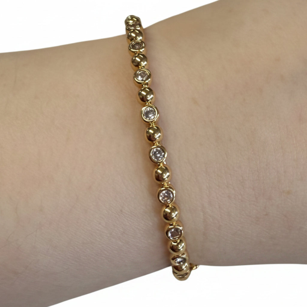 Gold hinge bracelet with round, bezel-set clear cubic zirconia. Available in sizes S/M and M/L.