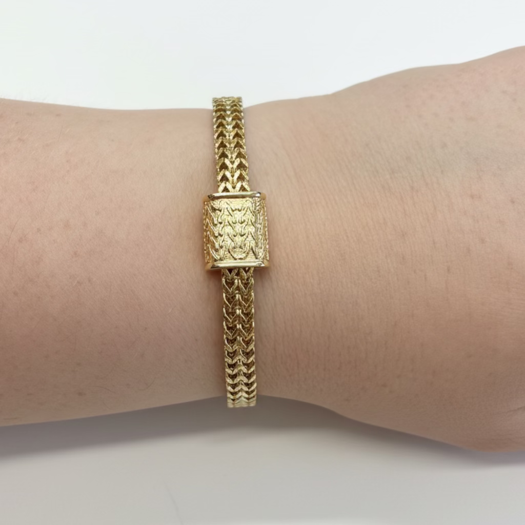Magnetic Dipped Metal Bracelet with intricate woven gold band and rectangular textured centerpiece. Available in S, M, and L.