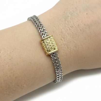 Silver woven chain bracelet with gold rectangular centerpiece, intricate pattern, magnetic closure. Available in S, M, L.
