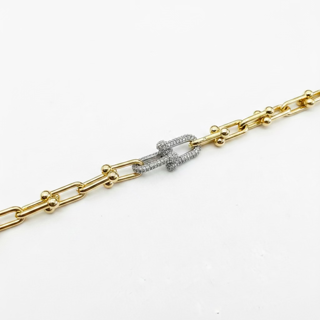Rectangular gold and silver links, gold spheres, diamond-encrusted silver clasp. Available in small, medium, and large.