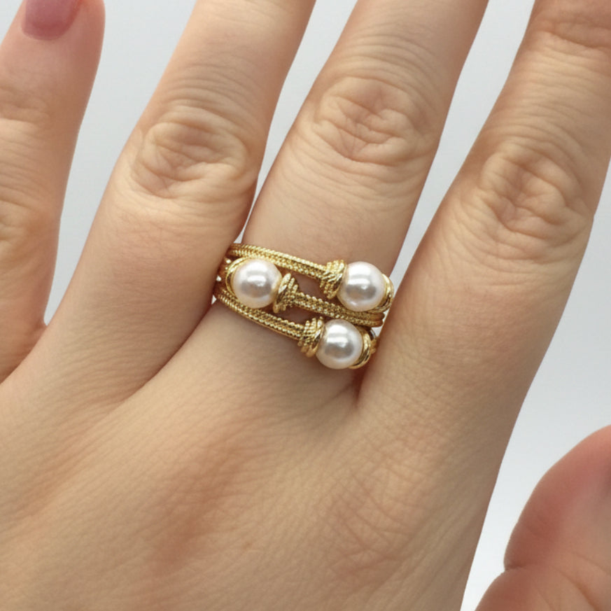 Gold wire ring with two parallel bands, each set with two white pearls (four total). Available in sizes 5–9.