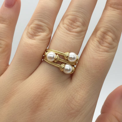 Gold wire ring with two parallel bands, each set with two white pearls (four total). Available in sizes 5–9.