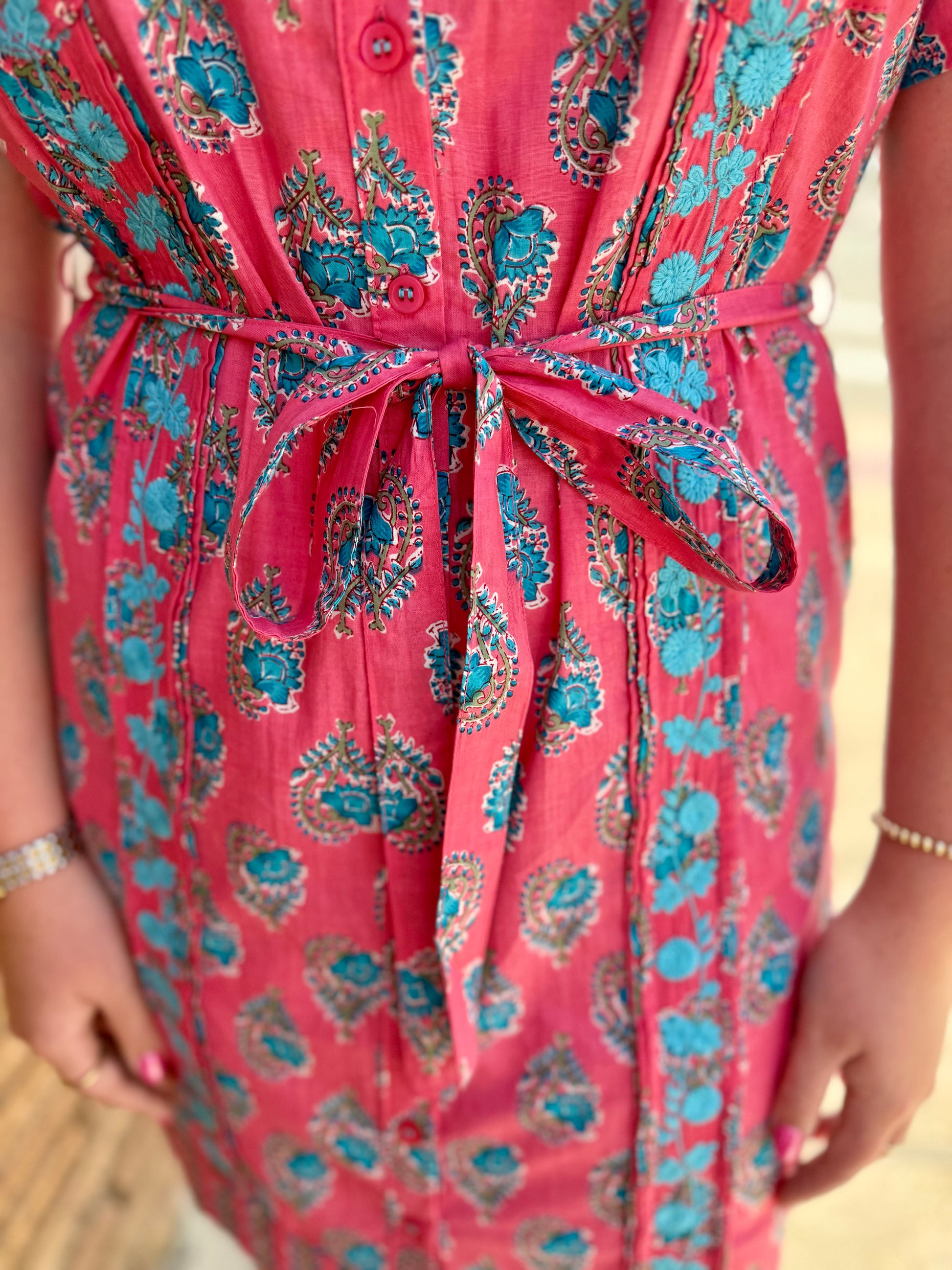Geranium Dominga Dress in blue and teal paisley with matching belt. Sizes: XS–XL.