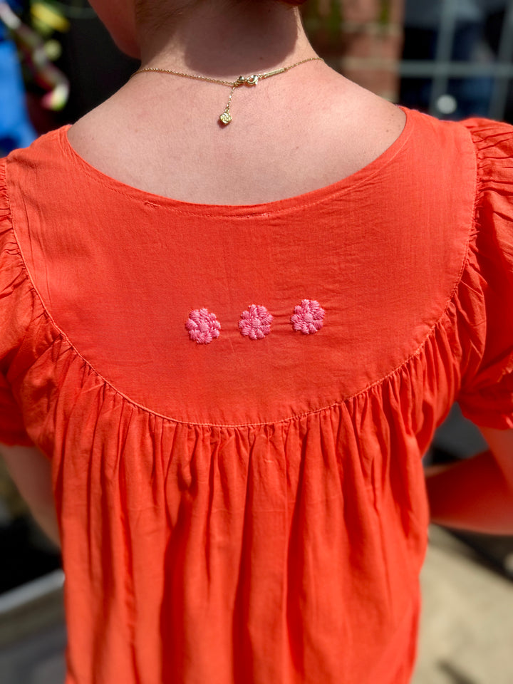 Cotton Daisy Filled Yoke Dress with mandarin orange daisy embroidery on back yoke. Available in XS–XL.