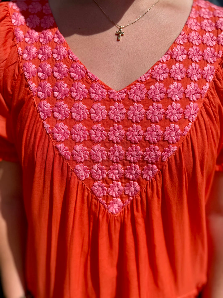 Daisy Filled Yoke Dress: mandarin orange cotton, pink floral V-embroidery. Available in sizes XS-XL.