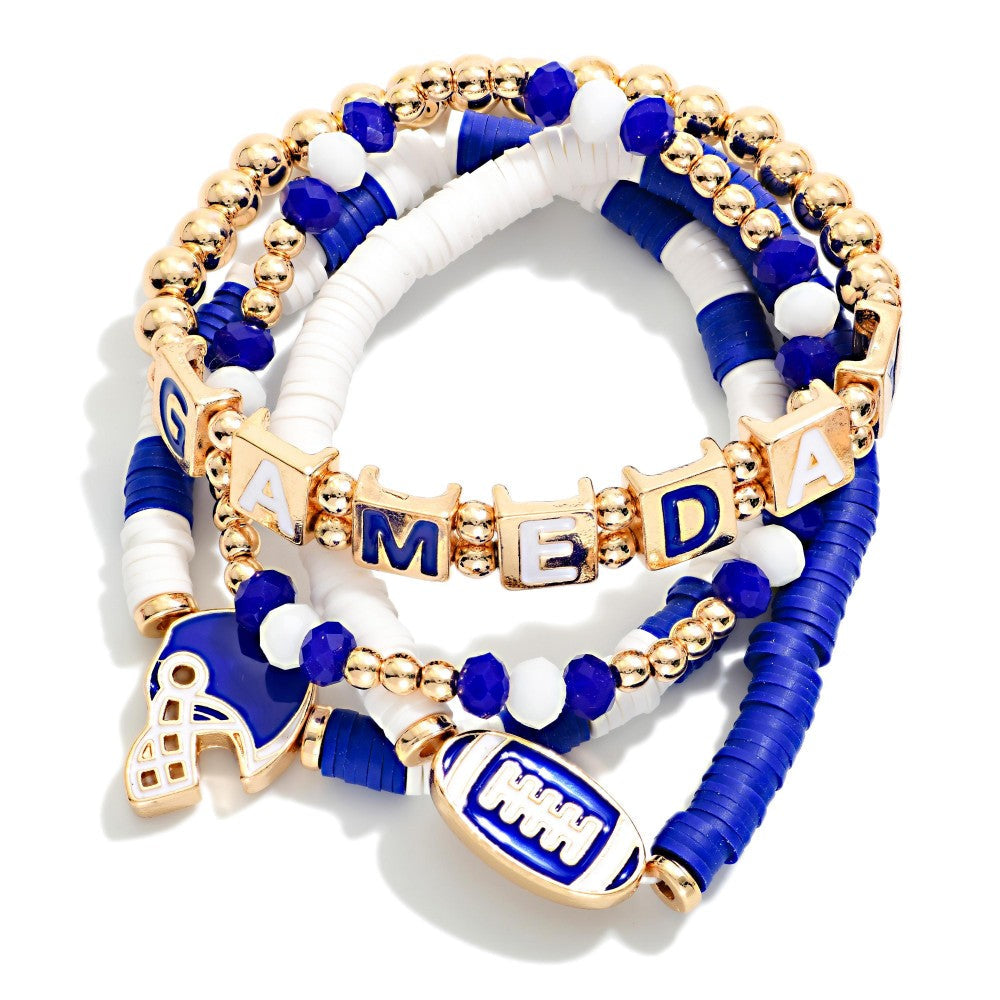 Stacked blue, white, and gold beaded stretch bracelets with football helmet charm, football charm, and gold letter beads spelling "GAMEDAY." Available sizes: S, M, L.