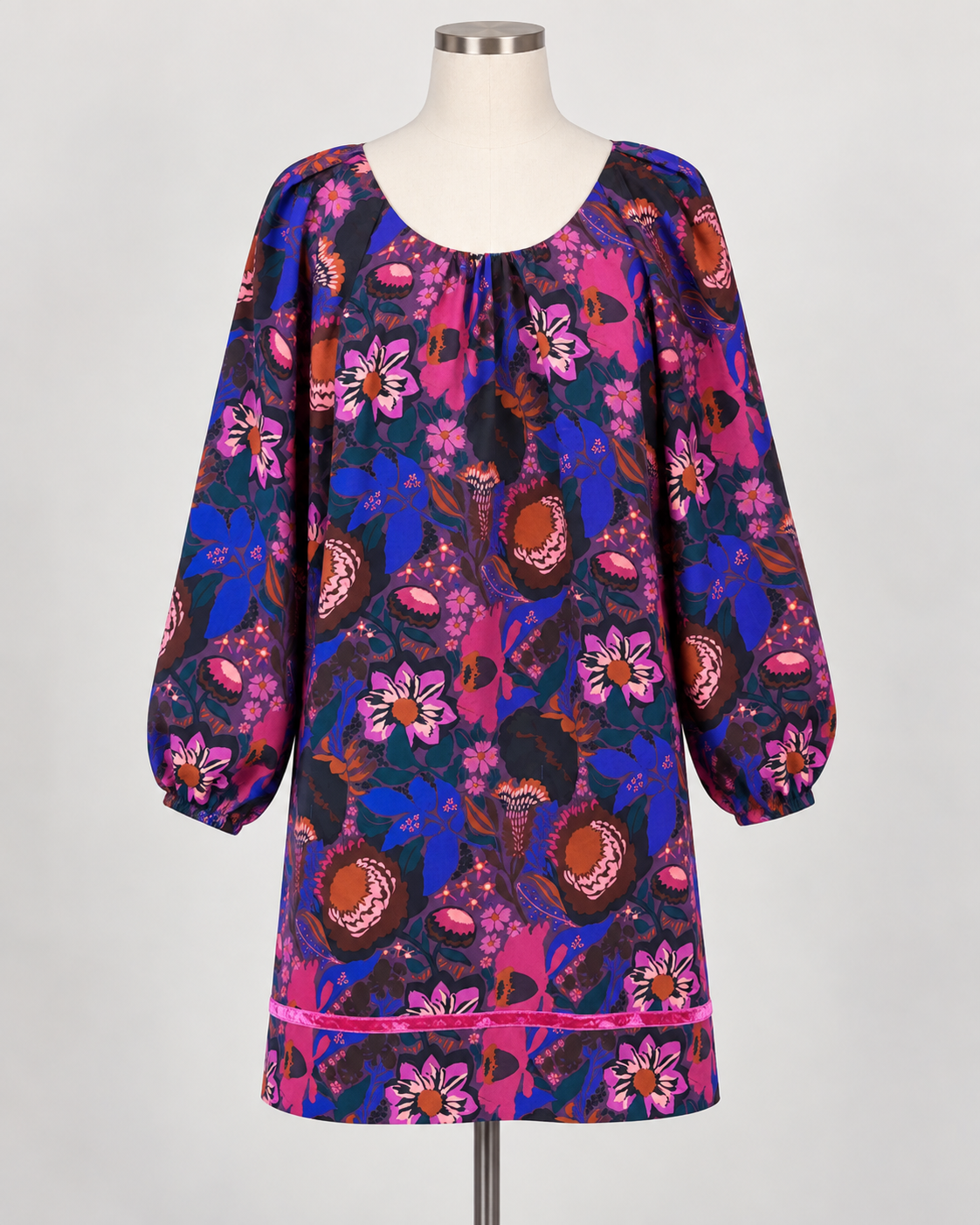 The Shirred Floral Shift Dress by Uncle Frank has long sleeves, a round neckline, and a vibrant pink, purple, and blue floral pattern. Available in sizes XS to XL.