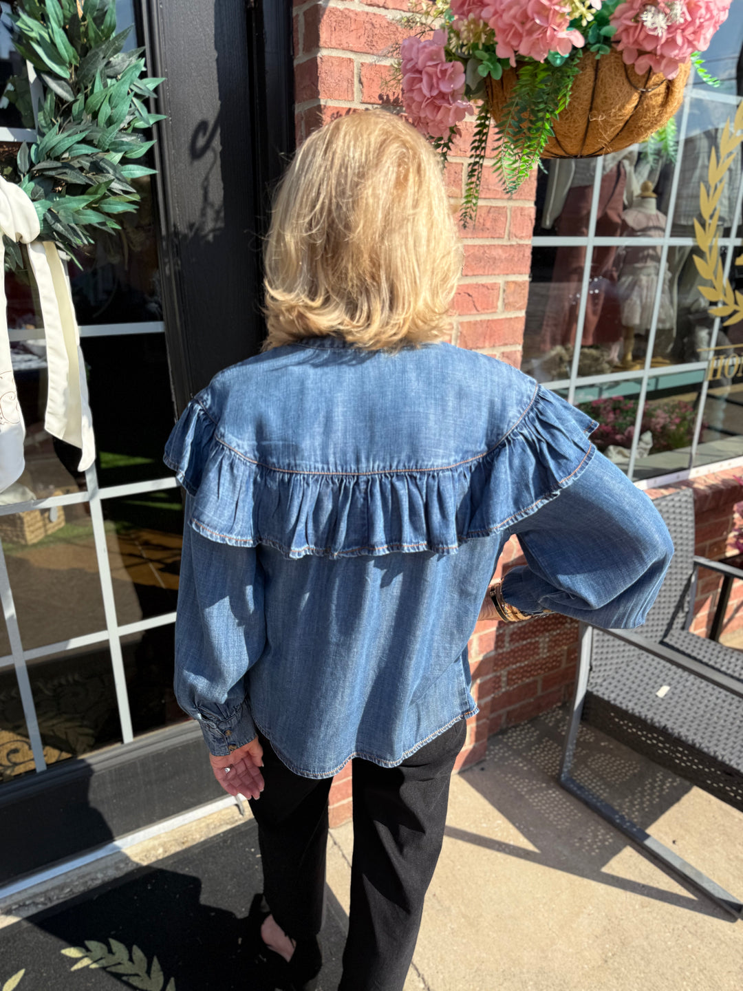 The Denim Bow Top is a ruffled Tencel denim shirt, available in sizes XS–XL.