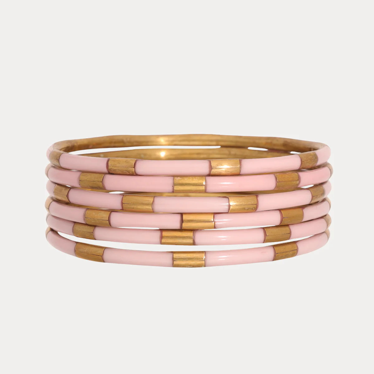 Six enamel bangles with alternating shiny gold and light pink segments. Available in small, medium, and large sizes.