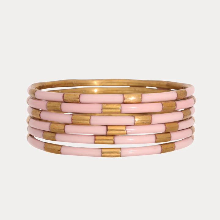 Six enamel bangles with alternating shiny gold and light pink segments. Available in small, medium, and large sizes.