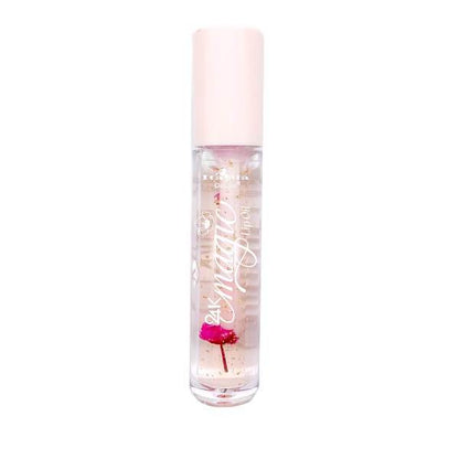 The 24K Magic Color Changing Lip Oil comes in a clear glass bottle with a light pink cap. It features a non-sticky, pH-activated pink formula with a small pink flower inside.