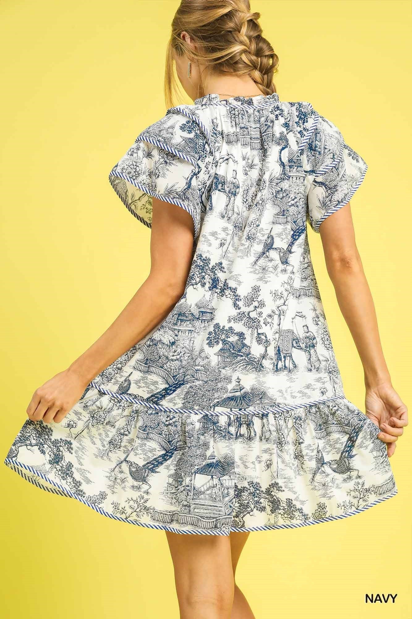 Toile Print Ruffle Hem Mini Dress in blue and white. Features ruffled hem detail. Available in sizes XS–XL.