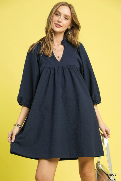 Textured Puff Sleeve Babydoll Dress in navy blue, loose fit, v-neckline, puffed sleeves. Available in sizes XS-XL.