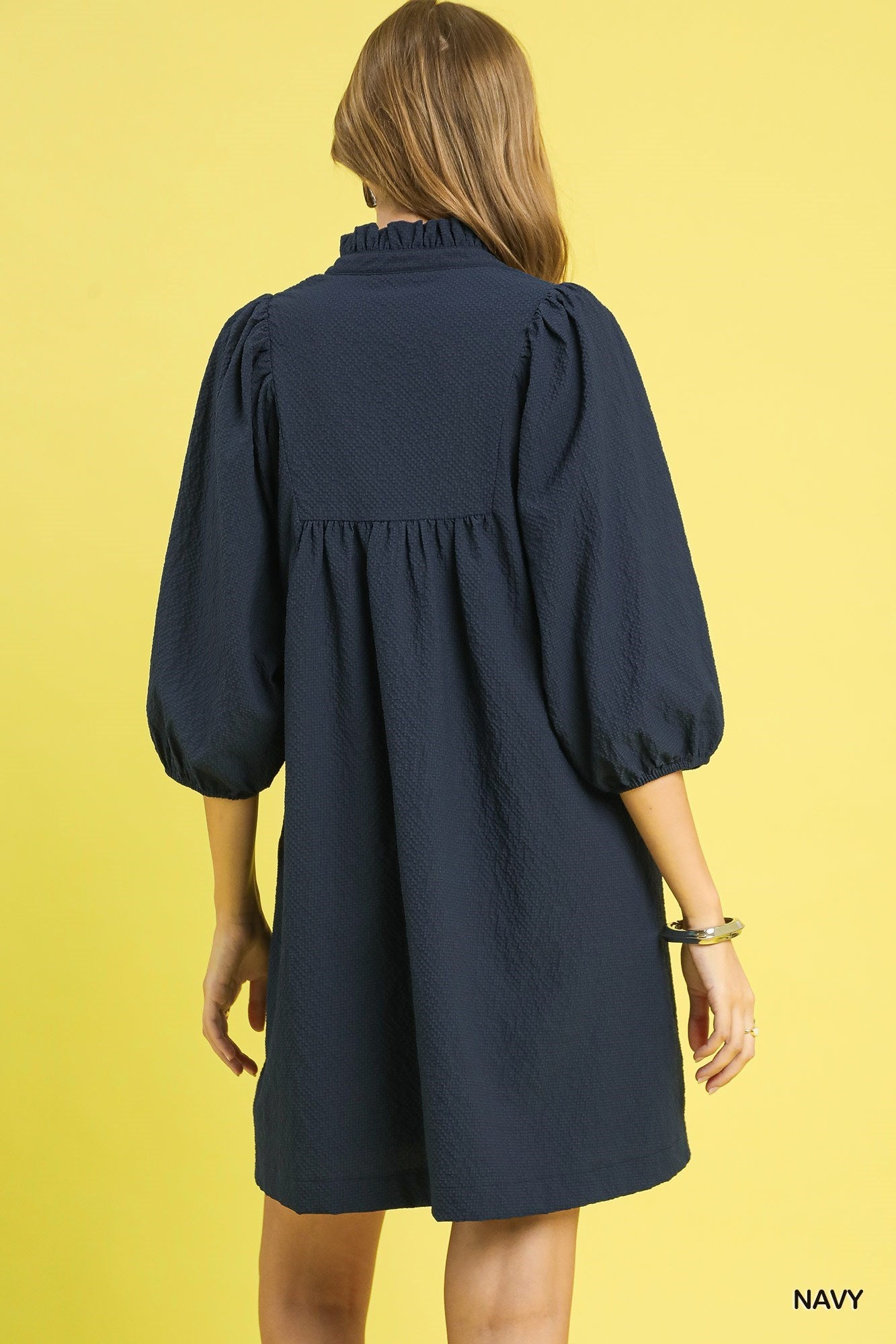 Textured Puff Sleeve Babydoll Dress in navy blue with three-quarter puff sleeves and ruffled collar. Sizes XS-XL.