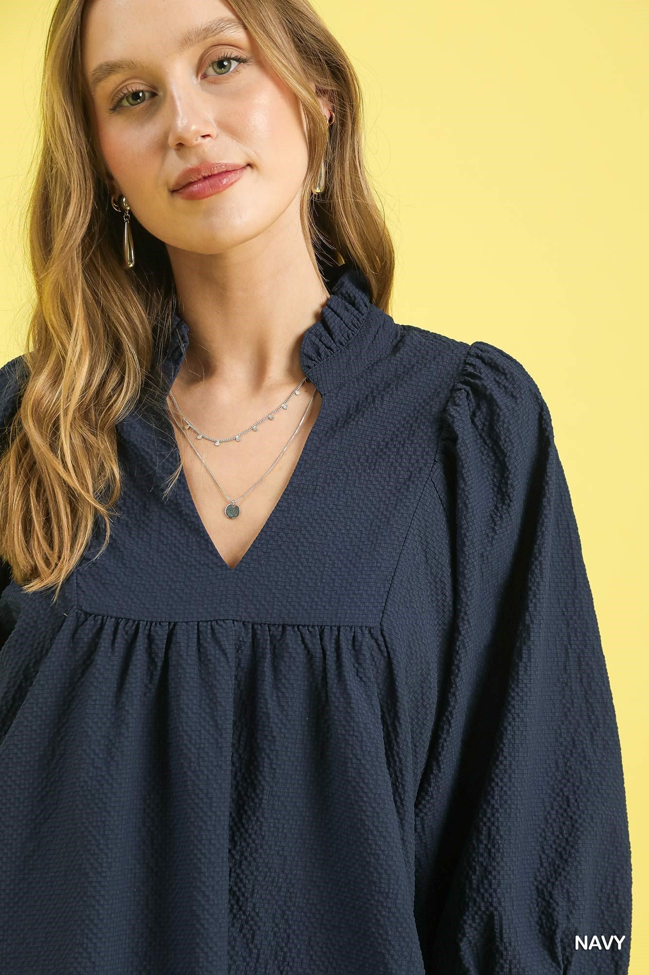 Textured Puff Sleeve Babydoll Dress in navy with a ruffled V-neck. Available in sizes XS-XL.