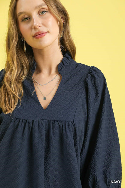 Textured Puff Sleeve Babydoll Dress in navy with a ruffled V-neck. Available in sizes XS-XL.