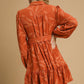 Piper Jacquard Dress with Tie Waist, rust color, long sleeves, leaf pattern. Available in sizes XS-XL.