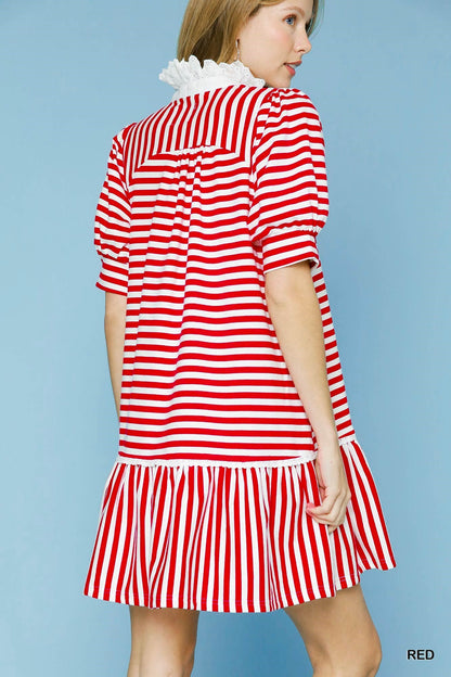 The Lacey Ruffle Dress has a red and white striped pattern, puffy sleeves, tiered ruffle hemline, sailor-style flap at the back, and a white lace collar on a light blue background. Available sizes: XS, S, M, L.