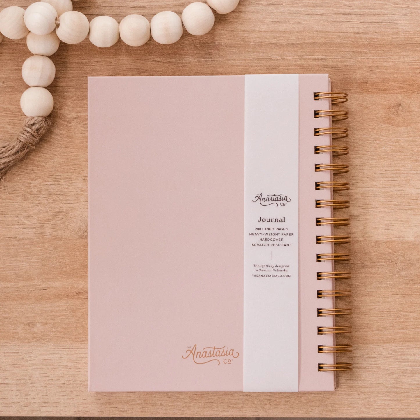 Pink, scratch-resistant spiral hardcover journal with "Anastasia" in cursive and lined pages. Available sizes: not specified.