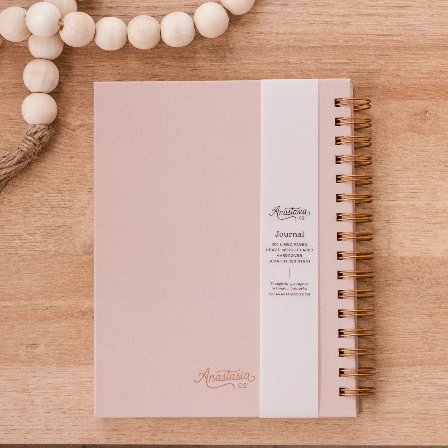 Pink, scratch-resistant spiral hardcover journal with "Anastasia" in cursive and lined pages. Available sizes: not specified.