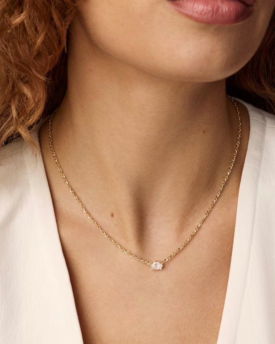 Cailin Gold Pendant Necklace in White Crystal by Kendra Scott with a delicate gold chain and small oval white crystal pendant; available in standard necklace lengths.
