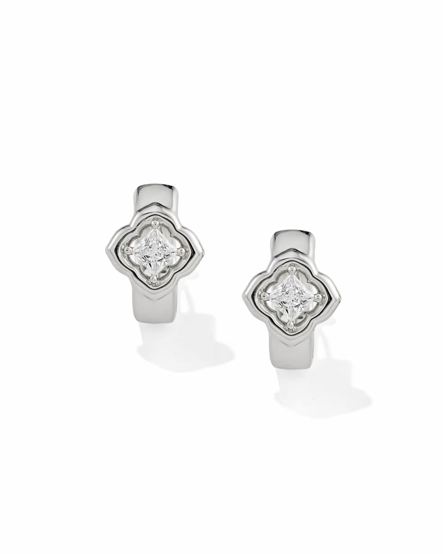 Mallory Crystal Silver Huggie Earrings by Kendra Scott with a quatrefoil design and central round white CZ in a raised bezel setting; available sizes: 0.52″ outer diameter, 0.32″ width.