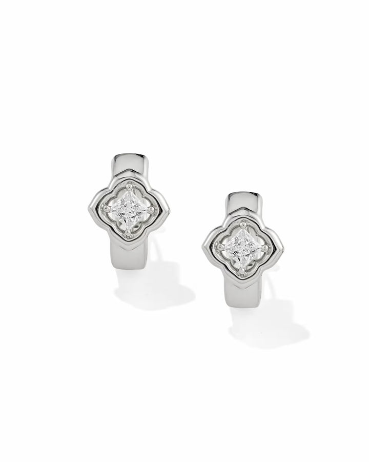 Mallory Crystal Silver Huggie Earrings by Kendra Scott with a quatrefoil design and central round white CZ in a raised bezel setting; available sizes: 0.52″ outer diameter, 0.32″ width.