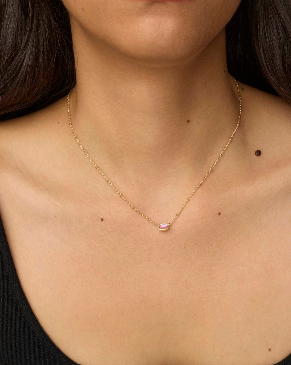 Mini Elisa Gold Satellite Short Pendant Necklace in Azalea Illusion by Kendra Scott, featuring a delicate 14k yellow gold chain and a small oval pink gemstone pendant. Available in 15–17 inch adjustable lengths.