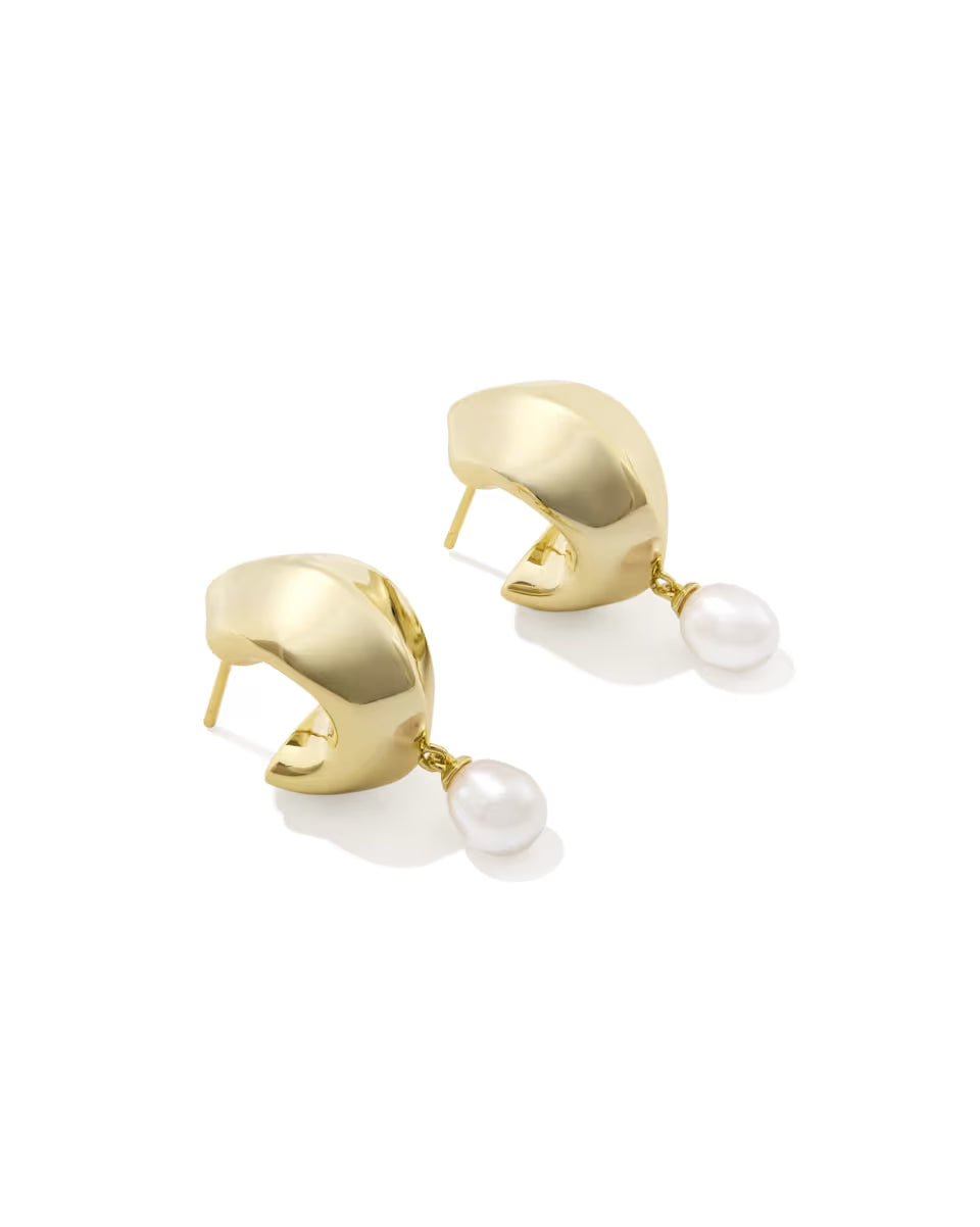 Polished gold huggie earrings with a single freshwater pearl suspended from each hoop. Available in multiple sizes.