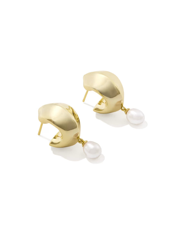 Polished gold huggie earrings with a single freshwater pearl suspended from each hoop. Available in multiple sizes.