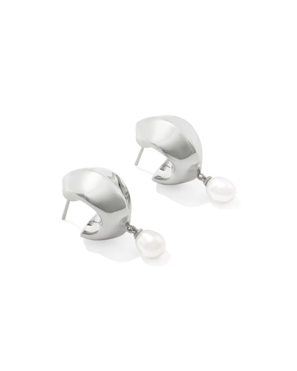Oakland Pearl Silver Huggie Earrings from Kendra Scott are small silver hoops with a single round freshwater pearl dangling at the bottom; available in standard earring size.