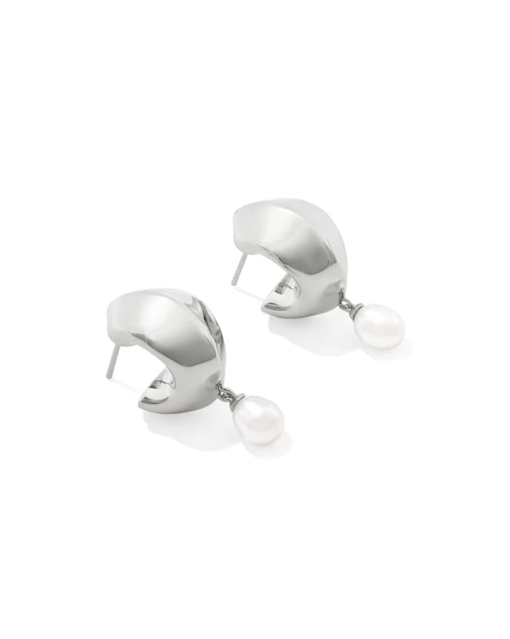 Oakland Pearl Silver Huggie Earrings from Kendra Scott are small silver hoops with a single round freshwater pearl dangling at the bottom; available in standard earring size.