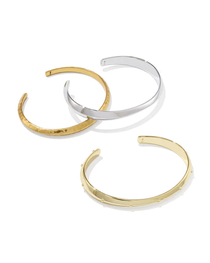 Set of three open-ended metal cuffs: one silver, one matte gold, and one shiny gold with raised dots. Available in S/M and M/L sizes.