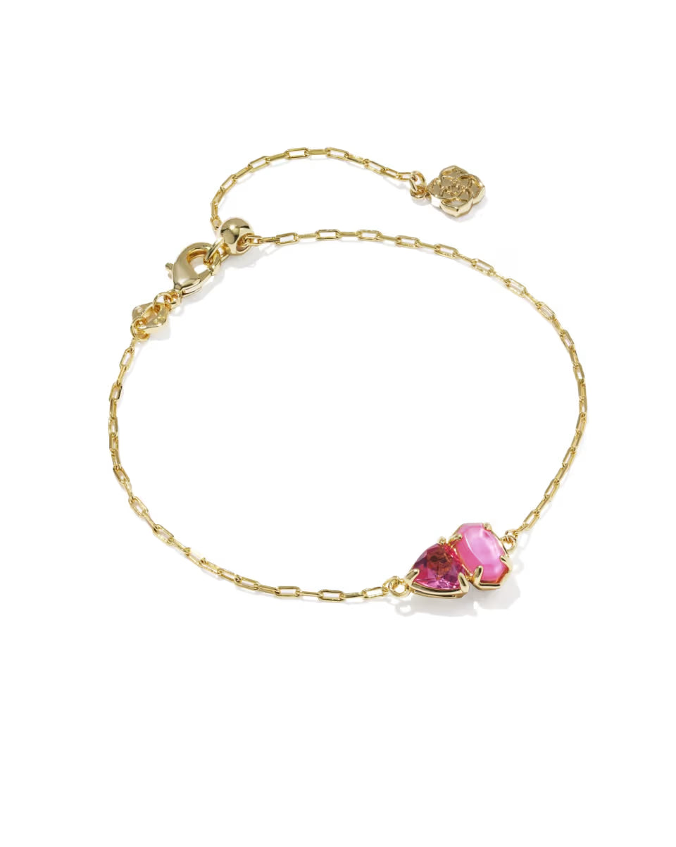 The Tatum Gold Delicate Chain Bracelet in Pink Mix by Kendra Scott has a pink heart-shaped gemstone and a small gold charm near the clasp. Available in standard bracelet sizes.