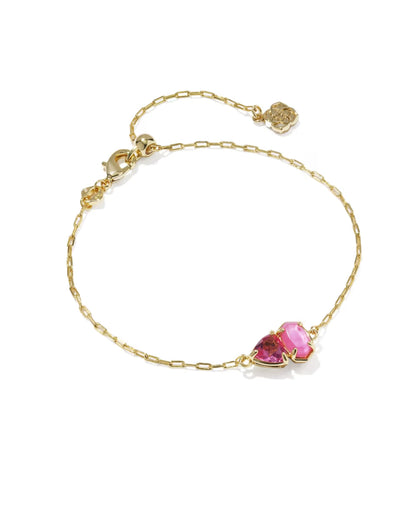 The Tatum Gold Delicate Chain Bracelet in Pink Mix by Kendra Scott has a pink heart-shaped gemstone and a small gold charm near the clasp. Available in standard bracelet sizes.