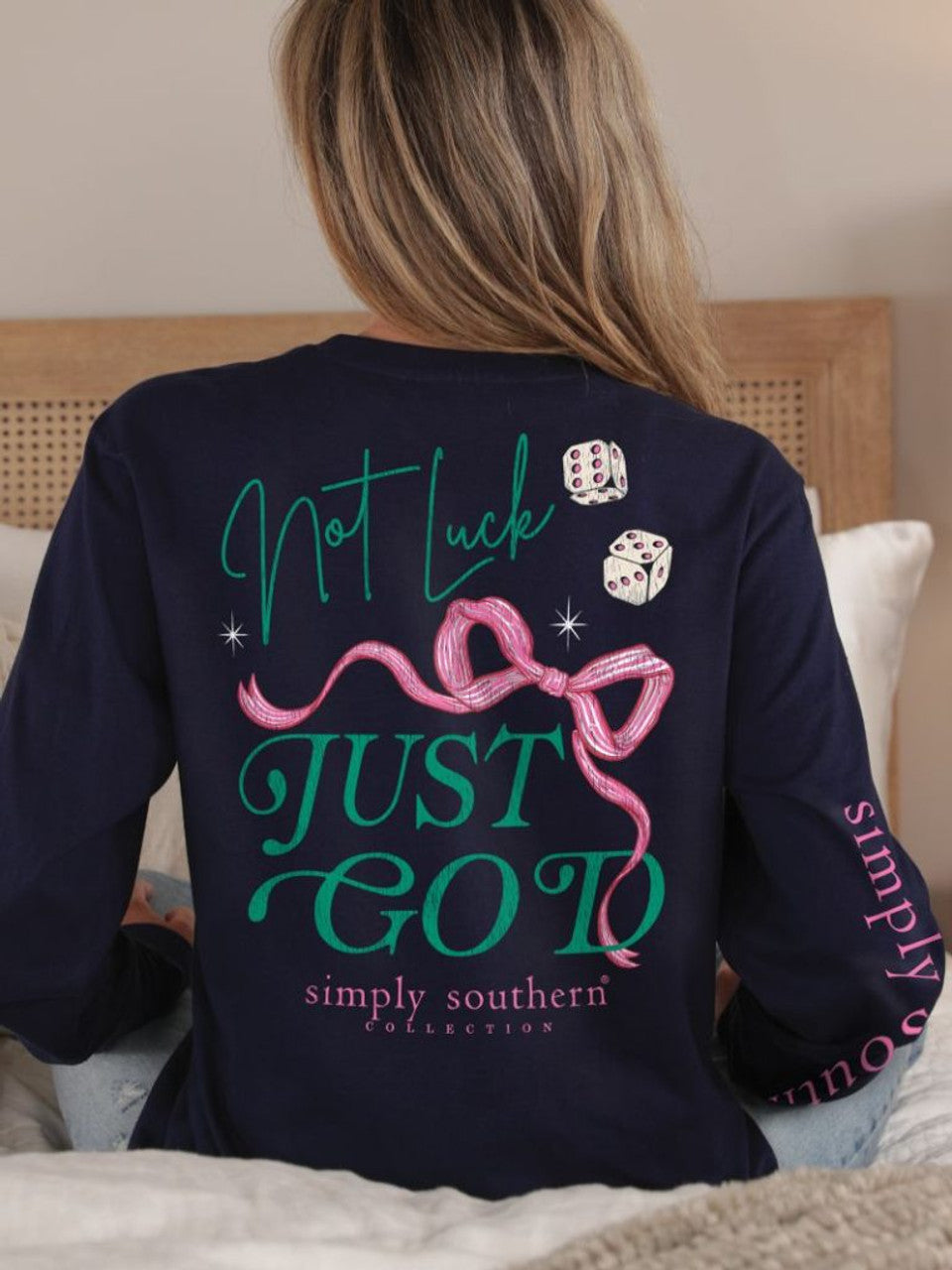 The "Not Luck Just God Long Sleeve T-Shirt in Eclipse" from Simply Southern features dice, a pink ribbon, and the phrase "Not Luck, Just God" in vibrant green and pink. Available sizes: S-XXL.