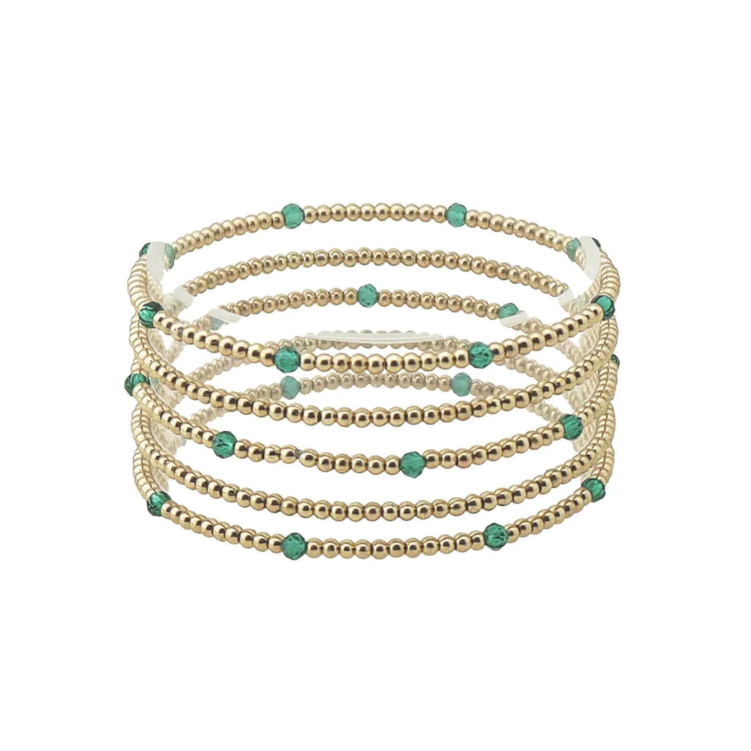 Set of seven thin gold and colored bead stretch bracelets with evenly spaced small turquoise beads, available in one size.