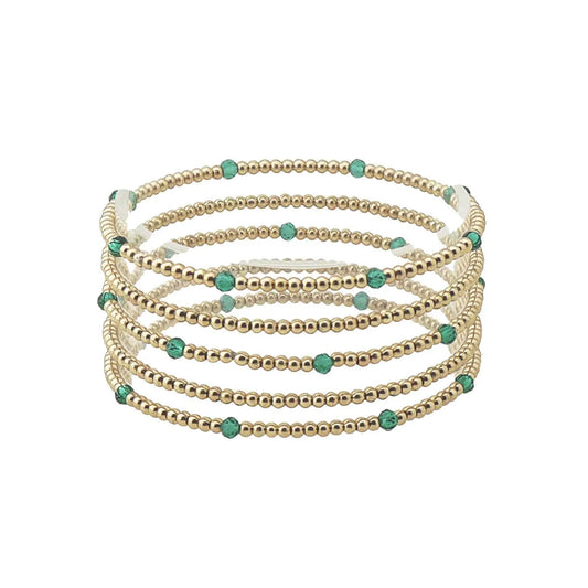 Set of seven thin gold and colored bead stretch bracelets with evenly spaced small turquoise beads, available in one size.